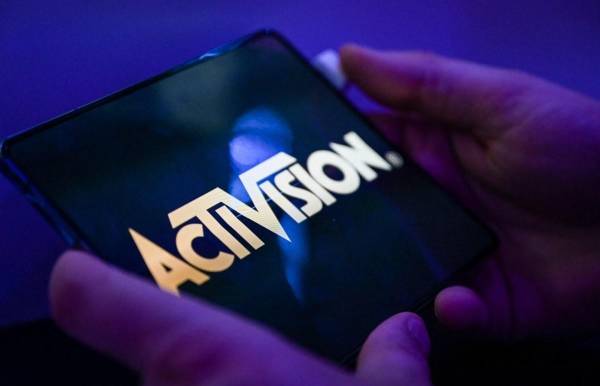 <i>Un visitante juega al juego 'Call of Duty' de Activision en un teléfono móvil en el stand de Samsung en la feria de videojuegos Gamescom en Colonia el 24 de agosto de 2022. FOTO INA FASSBENDER / AFP</i>