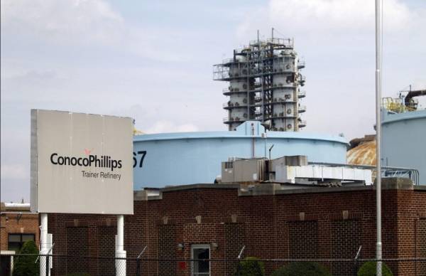 <i>MARCUS HOOK, PA - 1 DE MAYO: Un cartel se encuentra frente a la refinería de petróleo ConocoPhillips el 1 de mayo de 2012 en Trainer, Pensilvania. FOTO Jessica Kourkounis/Getty Images/AFPJessica Kourkounis / GETTY IMAGES NORTEAMÉRICA / Getty Images vía AFP</i>