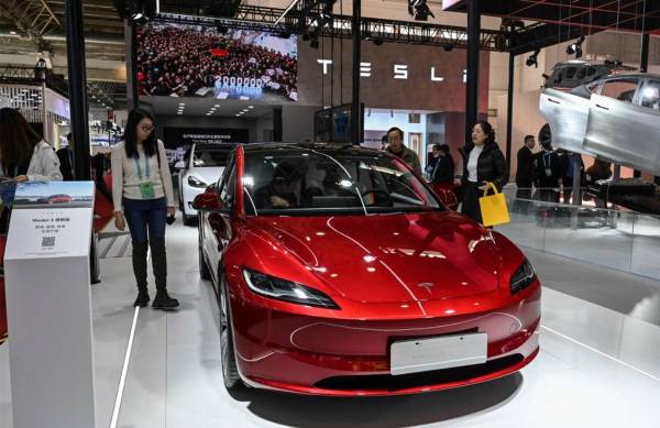 <i>La gente prueba el vehículo eléctrico Modelo 3 de Tesla en su stand durante la Exposición Internacional de la Cadena de Suministro de China (CISCE) en Beijing el 1 de diciembre de 2023. FOTO JADE GAO/AFP</i>