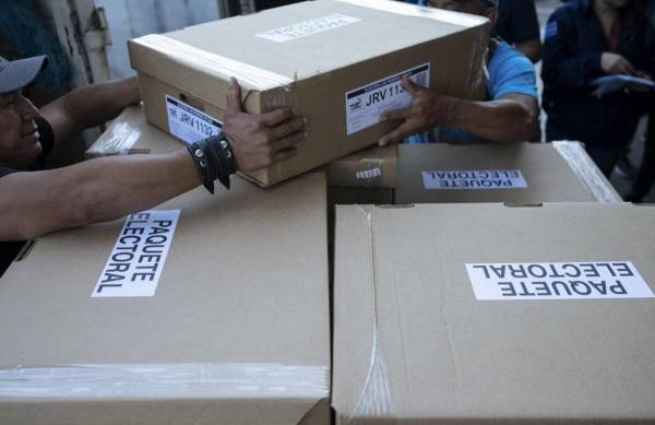 <i>Empleados del Tribunal Supremo Electoral (TSE) cargan cajas con material electoral para las elecciones presidenciales y legislativas que serán distribuidas en los diferentes municipios de la capital en la Dirección de Organización Electoral en San Marcos, El Salvador, el 2 de febrero de 2024. El Salvador va a las urnas el 4 de febrero. FOTO Yuri CORTEZ/AFP</i>