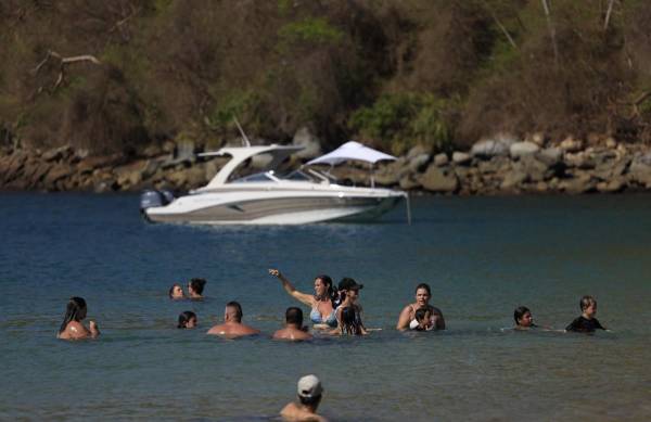 <i>Turistas se bañan en la playa de la isla Taboga en la ciudad de Panamá, el 30 de marzo de 2024.FOTO MARTÍN BERNETTI / AFP</i>