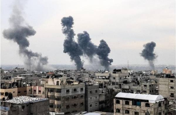 <i>Una fotografía tomada el 20 de diciembre de 2023 desde Rafah muestra humo ondeando después de los ataques israelíes sobre el campo de refugiados de Nuseirat en el centro de la Franja de Gaza, en medio de batallas en curso entre Israel y el grupo militante Hamas.Mahmud. FOTO HAMS / AFP</i>