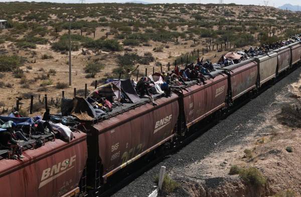 <i>Migrantes, en su mayoría de Venezuela, viajan en vagones de un tren de mercancías a Ciudad Juárez, estado de Chihuahua, México, el 3 de octubre de 2023. FOTO HERIKA MARTÍNEZ / AFP</i>