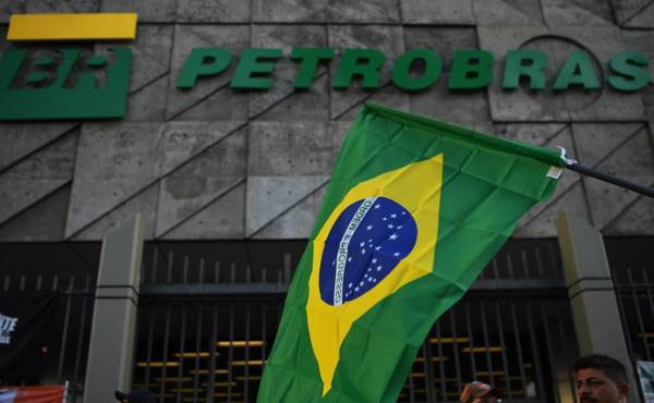 <i>(ARCHIVOS) Una bandera brasileña se ve durante una protesta contra los despidos frente a la sede de la petrolera estatal brasileña Petrobras en Río de Janeiro, Brasil, el 18 de febrero de 2020. FOTO CARL DE SOUZA/AFP</i>