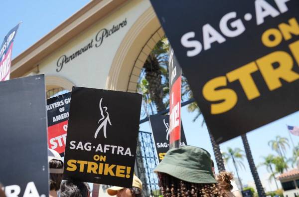 <i>Miembros y partidarios de SAG-AFTRA y WGA caminan en el piquete en Paramount Studios el 19 de julio de 2023 en Los Ángeles, California. Los miembros de SAG-AFTRA, el sindicato más grande de Hollywood que representa a actores y otros profesionales de los medios, se han unido a los trabajadores en huelga del WGA (Writers Guild of America) en la primera huelga conjunta contra los estudios desde 1960. FOTO JC Olivera/Getty Images/AFP</i>