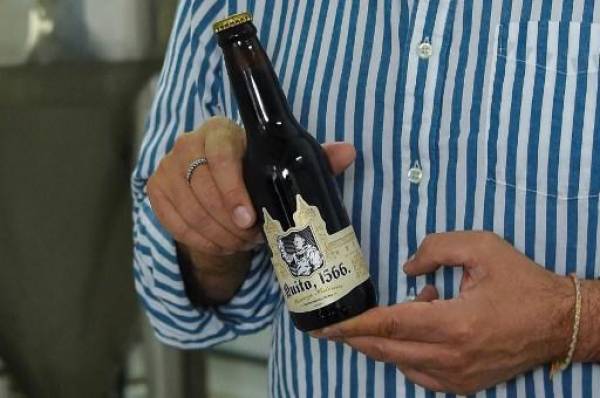 El científico ecuatoriano Javier Carvajal muestra una botella de cerveza artesanal elaborada con una levadura de 400 años que Carvajal resucitó en un laboratorio de su casa en Quito, el 25 de julio de 2022. - Dentro de una barrica de roble estaba el hongo de la fortuna. El bioingeniero ecuatoriano Javier Carvajal, de una astilla, resucitó una levadura de alrededor de 400 años y recreó la que se cree es la cerveza más antigua de América Latina. (Foto de Rodrigo BUENDIA / AFP)