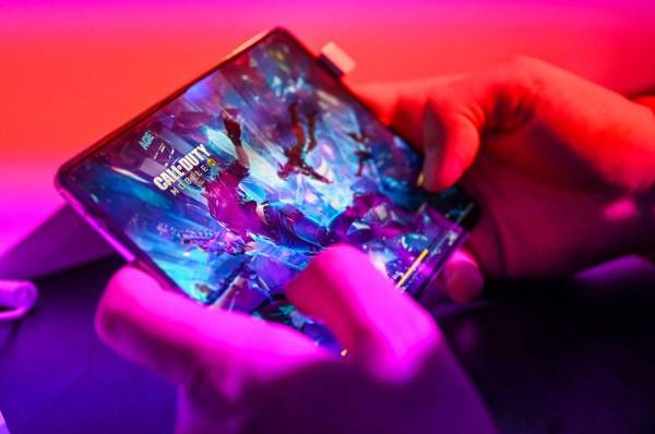 <i>Un visitante juega al juego 'Call of Duty' en un teléfono móvil en el stand de Samsung en la feria de videojuegos Gamescom en Colonia el 24 de agosto de 2022. FOTO Ina FASSBENDER / AFP</i>