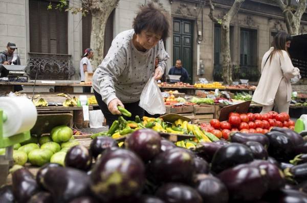 <i>Una mujer compra pimientos en un mercado callejero de Montevideo el 23 de abril de 2024. Con 3,4 millones de habitantes, Uruguay tiene el costo de vida más alto de América del Sur y supera al de varios países europeos y asiáticos más desarrollados.FOTO Pablo VERA/AFP</i>