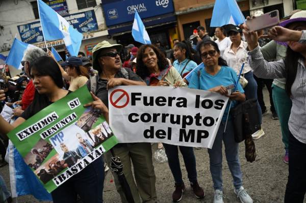 <i>La gente participaba en una manifestación para exigir la renuncia de la Fiscal General Consuelo Porras y del fiscal Rafael Curruchiche, acusados ​​de generar una crisis electoral, en la Ciudad de Guatemala, el 25 de agosto de 2023. (Foto de JOHAN ORDÉREZ / AFP/ ARCHIVOS)</i>