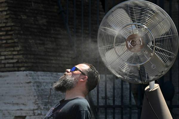 <i>Un ventilador rocía agua a lo largo de las puertas del Coliseo para refrescar a los turistas el 11 de julio de 2024 en Roma, donde las temperaturas alcanzan los 38 grados centígrados. FOTO Tiziana FABI/AFP</i>
