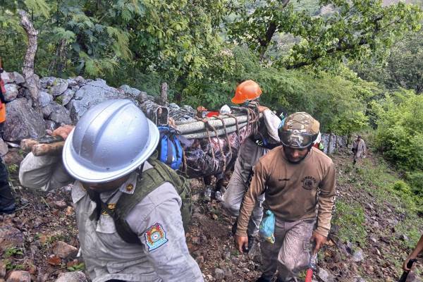 <i>Fotografía cedida por el Cuerpo de Bomberos de Honduras que muestra a algunos de sus integrantes rescatando el cuerpo de un hombre victima de las lluvias, en Nacoame (Honduras). El Gobierno de Honduras declaró este lunes estado de emergencia en cuatro departamentos del país, tres de ellos fronterizos con El Salvador, debido al temporal lluvioso que, en dos semanas, ha dejado al menos once personas muertas, más de 10.000 afectadas y daños materiales.EFE/ Bomberos De Honduras </i>