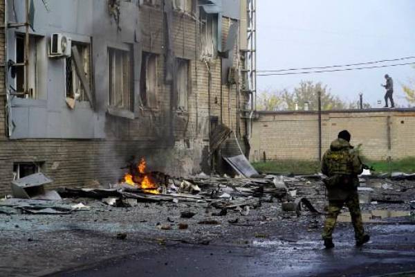 Un militar protege el sitio de la explosión de un coche bomba frente a un edificio que alberga una estación de televisión local en la ciudad rusa de Melitopol, en el sur de Ucrania, el 25 de octubre de 2022. FOTO STRINGER / AFP