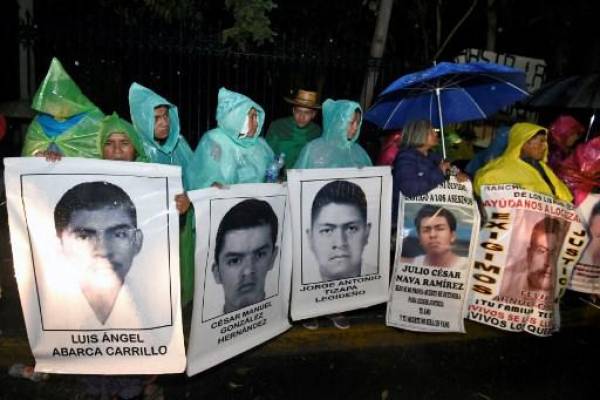 (ARCHIVOS) En esta foto de archivo tomada el 24 de diciembre de 2014, padres y familiares de los 43 estudiantes desaparecidos durante enfrentamientos con la policía local en la ciudad de Iguala, estado de Guerrero, exigen justicia durante una protesta en Nochebuena en las afueras de Los Pinos. Residencia Presidencial en la Ciudad de México. Soldados mexicanos tienen alguna responsabilidad, por acción u omisión, en la desaparición de 43 estudiantes de la escuela normal de Ayotzinapa en 2014, según un informe de una comisión gubernamental difundido el 18 de agosto de 2022.