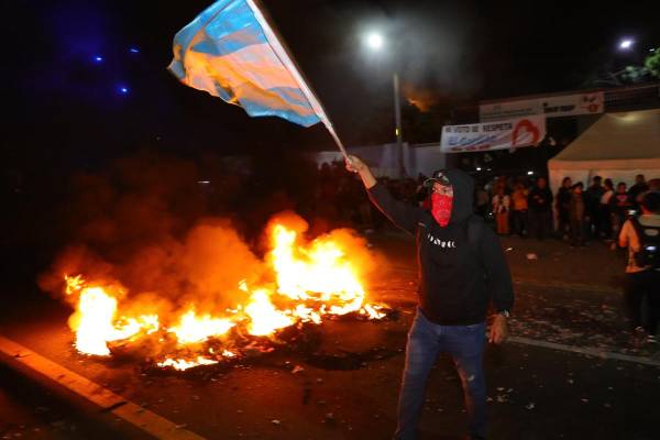 <i>Un hombre sostiene una bandera durante una manifestación este lunes, frente a las instalaciones del Instituto Nacional de Formación Profesional (Infop) en Tegucigalpa (Honduras). Militantes del oficialista Partido Libertad y Refundación (Libre, izquierda) de Honduras se manifestaron en las calles tras el llamado del expresidente Manuel Zelaya, quien, junto a la candidata Rixi Moncada, denunció un supuesto fraude en las elecciones. EFE/ Gustavo Amador</i>