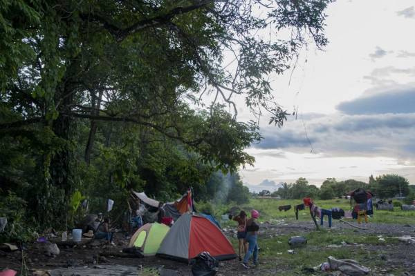 <i>FOTO. Migrantes descansan en el campamento de refugiados de Paso Canoas en Puntarenas, Costa Rica el 9 de agosto de 2023. Paso Canoas, el principal cruce fronterizo entre Panamá y Costa Rica, se ha convertido en una encrucijada para los migrantes: los que tienen dinero se quedan allí solo unas horas, y los que no ven su “sueño americano” convertirse en una “pesadilla”. (Foto por Ezequiel BECERRA / AFP)</i>