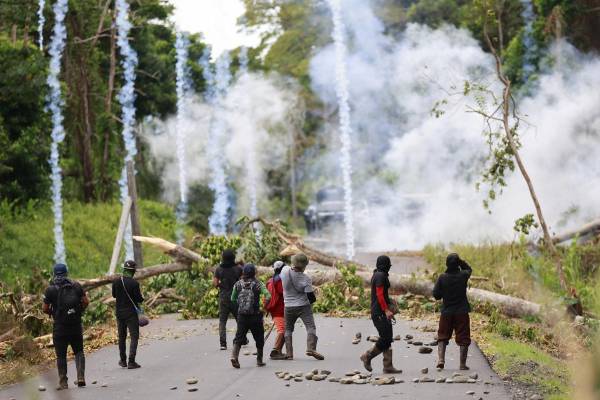 <i>Un manifestante se enfrenta con agentes de la Unidad de Control de Multitudes (UCM) este miércoles, en Valle de Agua Abajo en la provincia de Bocas del Toro (Panamá). Las fuerzas de seguridad de Panamá continúan con la 'Operación Omega' para tratar de despejar las vías en la provincia caribeña de Bocas del Toro, donde trabajadores del sector bananero se manifiestan desde hace más de un mes en contra de una reforma a la seguridad social. EFE/ Bienvenido Velasco</i>