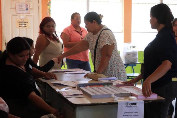 <i>Personas votan durante la jornada de las elecciones generales este domingo, en San Pedro Sula (Honduras). EFE/ José Valle</i>