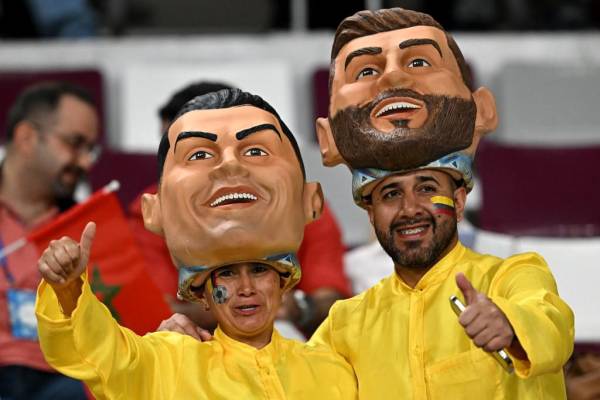 <i>Los aficionados al fútbol con máscaras del delantero portugués Cristiano Ronaldo y el delantero argentino Lionel Messi posan antes del partido de fútbol de la eliminatoria por el tercer puesto de la Copa Mundial de Qatar 2022 entre Croacia y Marruecos en el Estadio Internacional Khalifa en Doha el 17 de diciembre de 2022. (Foto de Paul ELLIS / AFP)</i>