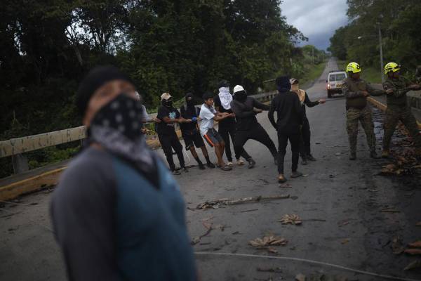 <i>Personas de la comunidad Piriati Embera ayudan a integrantes del Servicio Nacional de Fronteras a retirar unos cables eléctricos este jueves en Piriati (Panamá). EFE/ Bienvenido Velasco</i>