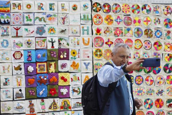 Una persona se toma una fotografía en la exposición de bordados y tejidos más grande del mundo este lunes, en el Complejo Cultural Los Pinos de la Ciudad de México (México). EFE/ Sáshenka Gutiérrez