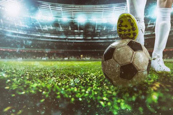 Football scene at night match with player ready to shoot the ball