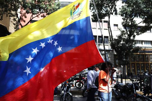 <i>Un simpatizante del oficialismo sostiene una bandera de Venezuela este sábado en inmediaciones del Palacio de Miraflores en Caracas (Venezuela). Chavistas salieron a las calles del centro de Caracas para exigir que devuelvan al mandatario venezolano, Nicolás Maduro, luego de que el líder estadounidense, Donald Trump, anunciara la captura del gobernante suramericano en medio de un ataque con misiles durante la madrugada de hoy contra la capital venezolana y otras zonas del país. EFE/ Miguel Gutiérrez</i>