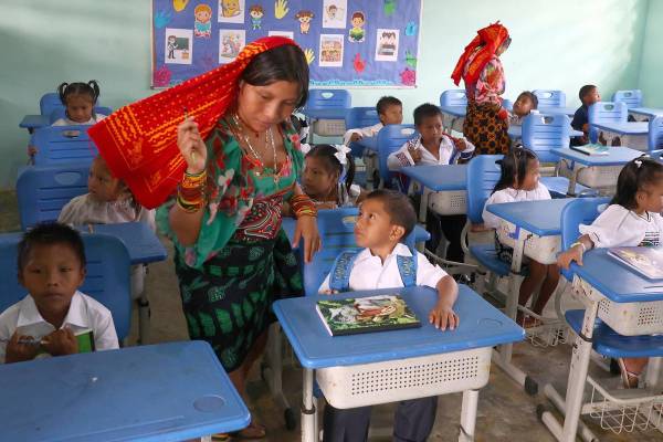 <i>Niños de distintas comunidades indígenas asisten a una clase en el Centro Educativo Bilingüe Icanti este lunes, en Icanti (Panamá). Degidde nuegambi. Así se dice hola, ¿cómo están? en dulegayá, el idioma de la etnia guna, y es la pregunta con la que un docente recibe a un grupo de infantes vestidos con las prendas tradicionales indígenas en el primer día de clases en el Centro Educativo Bilingüe Icanti, situado en esta apartada comunidad de la comarca Madugandí de Panamá. EFE/ Carlos Lemos</i>