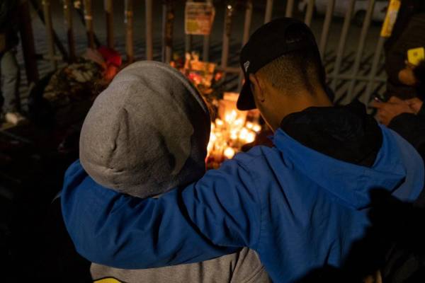 <i>Una pareja presenta sus respetos durante una vigilia frente a las instalaciones de inmigración mexicanas donde al menos 38 migrantes murieron en un incendio, en Ciudad Juárez, estado de Chihuahua, el 28 de marzo de 2023, México. (Foto de Guillermo Arias / AFP)</i>