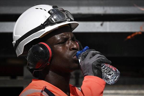 <i>Un trabajador bebe agua durante las obras de mantenimiento de las vías del tranvía en Burdeos, en el suroeste de Francia, el 29 de julio de 2024, mientras una ola de calor se extiende por las zonas del sur del país. FOTO Philippe LOPEZ / AFP</i>