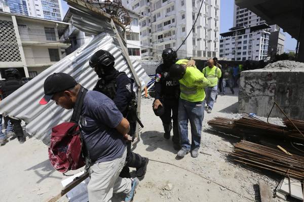 <i>Policías antidisturbios custodian a integrantes de grupos sindicales durante protestas este miércoles en Ciudad de Panamá (Panamá). Grupos sindicales y la Policía de Panamá se enfrentaron este miércoles en la capital, dejando al menos un agente antidisturbios herido, mientras se espera el avance de las discusiones parlamentarias para reformar la Seguridad Social, inmersa en una profunda crisis desde hace años. EFE/ Carlos Lemos</i>