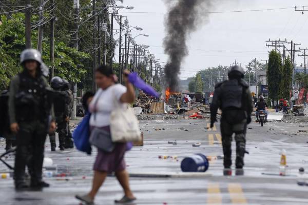 <i>Civiles y policías fueron captados este domingo, 22 de junio, en una calle bloqueada durante una nueva jornada de protestas, en Changuinola (Bocas del Toro, Panamá). EFE/Bienvenido Velasco</i>