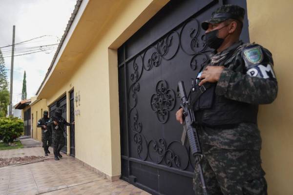 Miembros de la Policía Militar de Honduras hacen guardia en una lujosa casa durante un allanamiento en Tegucigalpa el 12 de diciembre de 2022. - Diez casas de lujo fueron allanadas en Honduras el lunes por fiscales y policías en busca de pruebas para combatir los cárteles de la droga, dijo el Ministerio Público. . (Foto por Johny Magallanes / AFP)