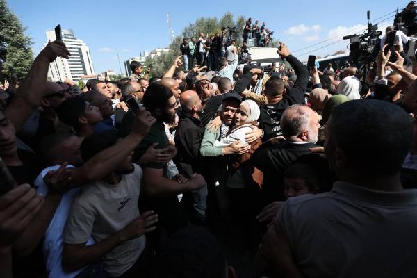 <i>La gente saluda a los presos palestinos liberados a su llegada a Ramala tras ser puestos en libertad de una cárcel israelí como parte del acuerdo de liberación entre Israel y Hamás. EFE/ALAA BADARNEH</i>
