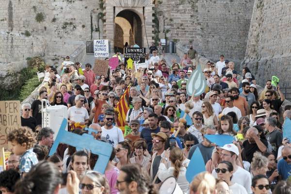 <i>Manifestación convocada por 'Caviem el rumb' contra la masificación turística este domingo, en Ibiza (Islas Baleares). Miles de personas se manifestaron este domingo en varias ciudades españolas como Barcelona, Palma, San Sebastián y Granada contra el turismo masivo, un modelo que, según denuncian, expulsa a los vecinos de los barrios y dispara el precio de la vivienda. EFE/ Sergio G. Canizares</i>