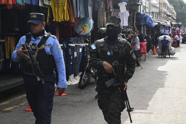 <i>Un miembro del Ejército de Honduras y la Policía Nacional patrullan una calle durante un operativo de seguridad llamado Mercados Seguros en Tegucigalpa el 14 de julio de 2023. Los índices de violencia y delincuencia están bajando en Honduras, luego de que la presidenta Xiomara Castro ordenara el desarme de las pandillas Barrio-18 y Mara Salvatrucha (MS-13) en las 21 cárceles del país y la implementación de toques de queda en los municipios de Choloma y San Pedro Sula, en el norte Honduras. Foto Orlando Sierra / AFP</i>