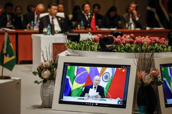 <i>Los delegados asisten a la sesión plenaria mientras el presidente ruso Vladimir Putin pronuncia su discurso virtualmente durante la Cumbre BRICS 2023 en el Centro de Convenciones Sandton en Johannesburgo el 23 de agosto de 2023. (Foto de GIANLUIGI GUERCIA / POOL / AFP)</i>