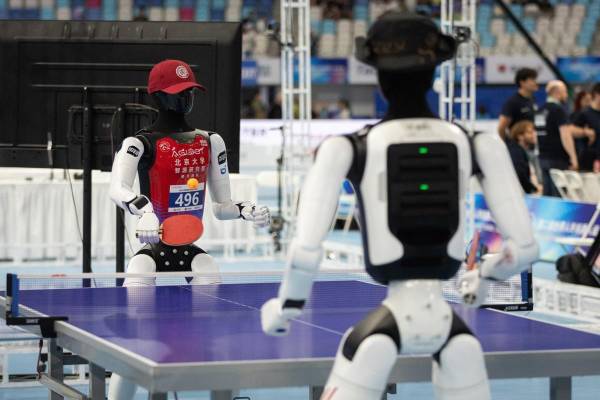 <i>Dos robots compiten en tenis de mesa durante los Juegos Robóticos que se disputaron en Pekín en agosto. EFE/EPA/JESSICA LEE</i>