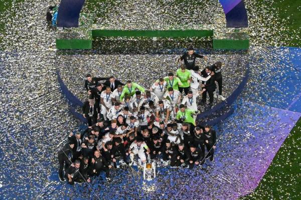 Los jugadores del Real Madrid celebran su victoria con el trofeo en el podio tras disputar la final de la Liga de Campeones de la UEFA contra el Borussia Dortmund, en el estadio de Wembley, en Londres, el 1 de junio de 2024. (Foto de Ben Stansall / AFP )