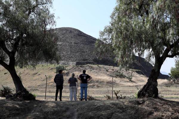 <i>Personas observan la zona arqueológica de Teotihuacán este martes, en San Juan Teotihuacán (México). Las puertas de la Zona Arqueológica de Teotihuacán (centro de México) permanecen cerradas y los alrededores de la Pirámide de la Luna, donde fueron baleadas varias personas en un tiroteo que dejó dos personas fallecidas, una de nacionalidad canadiense, y trece heridos, no está presente ningún elemento de seguridad, ni local ni federal. EFE/ Mario Guzmán</i>