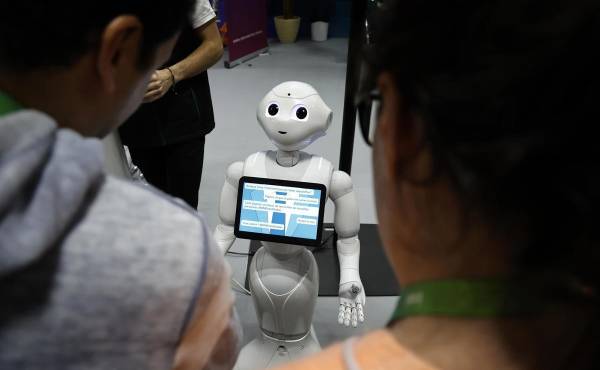 <i>Unos visitantes hablan con el robot 'Pepper' en una imagen de archivo de una feria. EFE/EPA/SEBASTIEN NOGIER</i>
