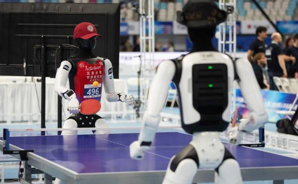 <i>Dos robots compiten en tenis de mesa durante los Juegos Robóticos que se disputaron en Pekín en agosto. EFE/EPA/JESSICA LEE</i>
