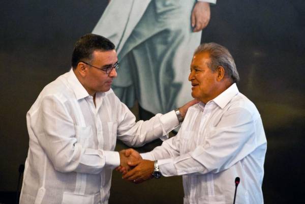 <i>ARCHIVO. El expresidente de El Salvador Mauricio Funes (izquierda) le da la mano al expresidente Salvador Sánchez Cerén (derecha) durante una reunión del equipo de transición del gobierno en San Salvador el 17 de marzo de 2014. FOTO AFP/ José CABEZAS </i>