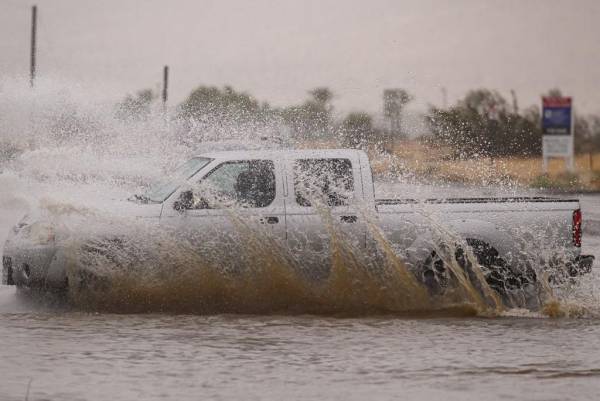 <i>Un vehículo conduce a través de una intersección inundada cuando la tormenta tropical Hilary toca tierra en Palm Springs, California el 20 de agosto de 2023. Fuertes lluvias azotaron California el 20 de agosto cuando la tormenta tropical Hilary se acercó desde México, trayendo advertencias de inundaciones potencialmente mortales en el típicamente árido suroeste de los Estados Unidos. (Foto de JOSH EDELSON / AFP)</i>