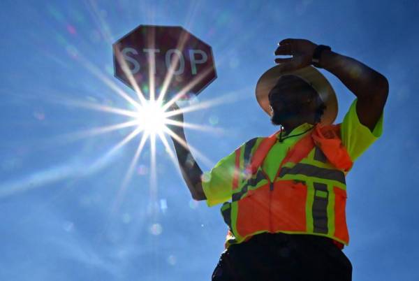 <i>El guardia de tráfico Rai Rogers atiende la esquina de su calle durante un turno de 8 horas bajo el sol abrasador en Las Vegas, Nevada, el 12 de julio de 2023. FOTO Frédéric J. BROWN / AFP</i>