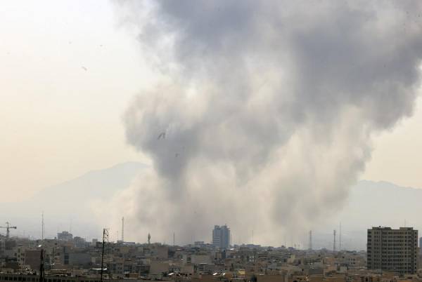 <i>Una columna de humo emerge del centro de Teherán tras un ataque israelí este sábado. Irán anunció este sábado el cierre de su espacio aéreo después de que se escucharan varias explosiones en diversos puntos de Teherán y de que Israel informara de que ha lanzado un ataque preventivo contra el país persa. EFE/ABEDIN TAHERKENAREH</i>