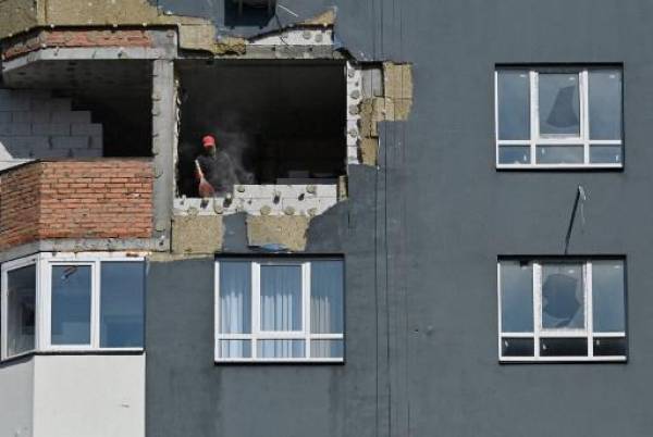 Un trabajador retira los escombros durante las obras de reparación de un bloque de apartamentos parcialmente destruido por los bombardeos en la ciudad de Irpin, región de Kyiv, el 16 de septiembre de 2022. Más de cien bloques residenciales en Irpin, apodada una “ciudad heroica” por el presidente Volodomyr Zelensky por retener ruso invasores que se dirigían a la capital- resultaron gravemente dañados por los bombardeos. Ahora, el avance del invierno presenta una amenaza diferente con reparaciones de edificios que se necesitan con urgencia para defenderse de los elementos.Serguéi SUPINSKY / AFP