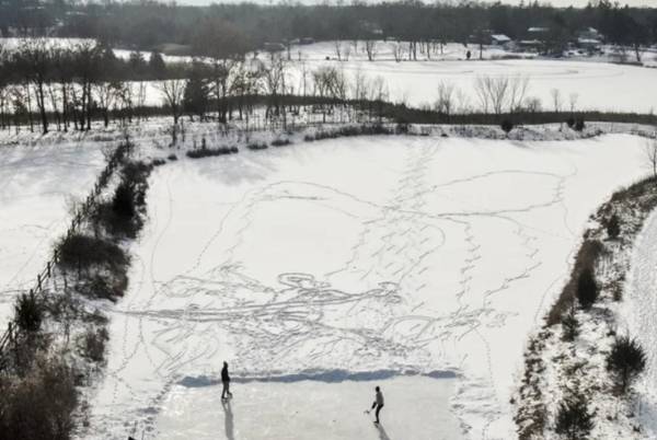 <i>Una foto aérea muestra a dos hombres practicando hockey sobre hielo en un estanque tras despejar una zona de nieve en Round Lake Heights, Illinois, Estados Unidos. EFE/EPA/Tannen Maury</i>