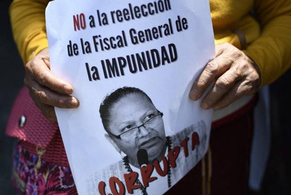 <i>ARCHIVO. Una persona sostiene un cartel contra la reelección de la fiscal general de Guatemala, Consuelo Porras, durante una protesta en la ciudad de Guatemala, el 6 de abril de 2022. FOTO Johan ORDÓNEZ / AFP</i>