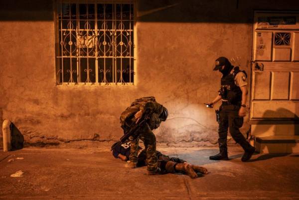 <i>Soldados de la Quinta Brigada de Infantería escanean a un hombre mientras participan con agentes de policía en una operación de seguridad y buscan sospechosos durante el toque de queda, en un barrio pobre de Guayaquil, Ecuador, en las primeras horas del 12 de enero de 2024. FOTO YURI CORTEZ / AFP</i>