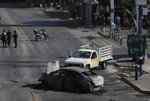 Fotografía que muestra un bloqueo con vehículos incendiados este domingo, en una vía de Guadalajara (México). EFE/ Francisco Guasco